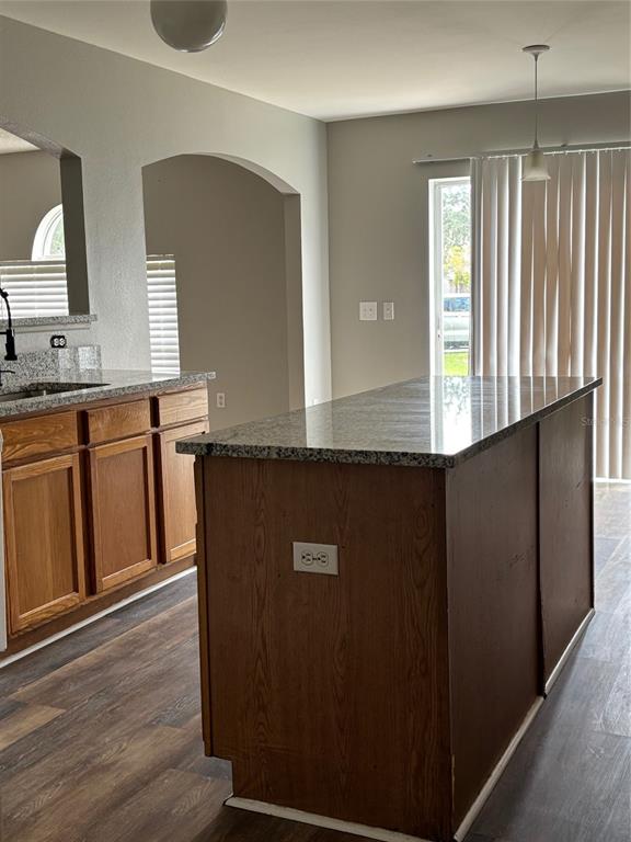 A kitchen features a granite-topped island, wooden cabinets, and a sliding glass door — 11102 SUMMER STAR DRIVE, RIVERVIEW, FL