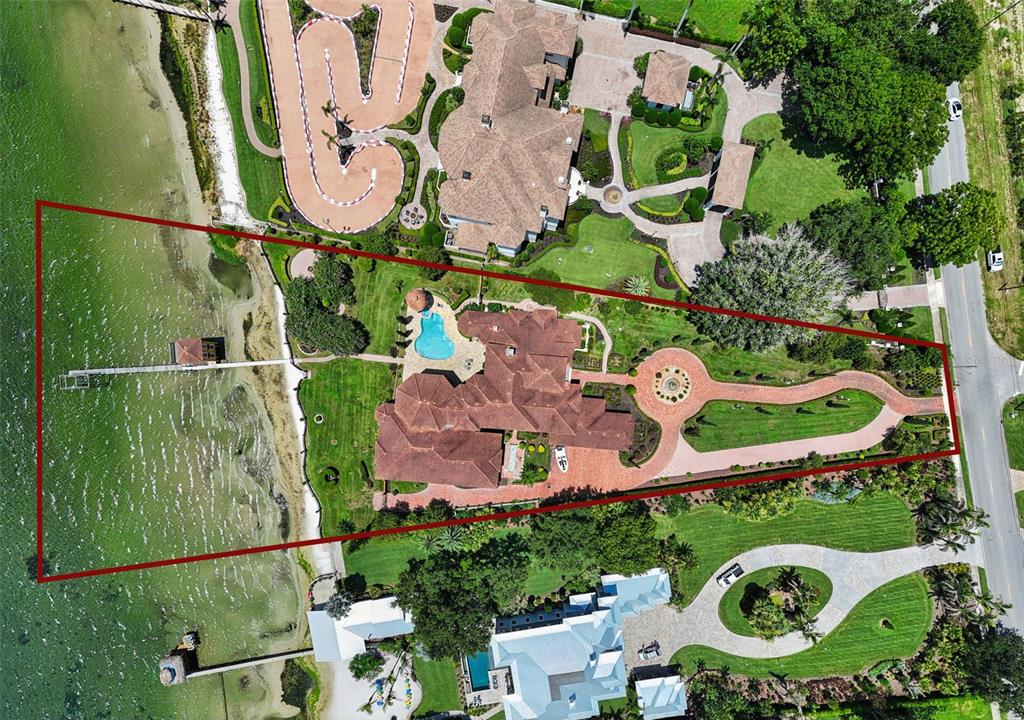 Aerial view of a waterfront estate featuring a large house, pool, dock, and circular driveway — 2961 LAKEVIEW DRIVE, SEBRING, FL