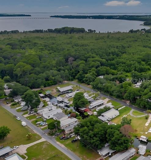 An aerial view shows a waterfront property with a small house and boat dock — 13450 PALM DRIVE, ASTATULA, FL