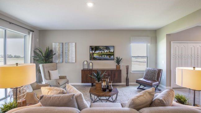 A living room features a television, a wooden console, a coffee table, and seating furniture — 1927 TRAVELERS PALM DRIVE, EDGEWATER, FL