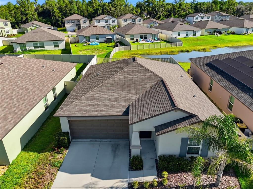 A single-story house with a tan exterior, a palm tree, and a for-sale sign — 4316 TROTTERS WAY, LAKELAND, FL