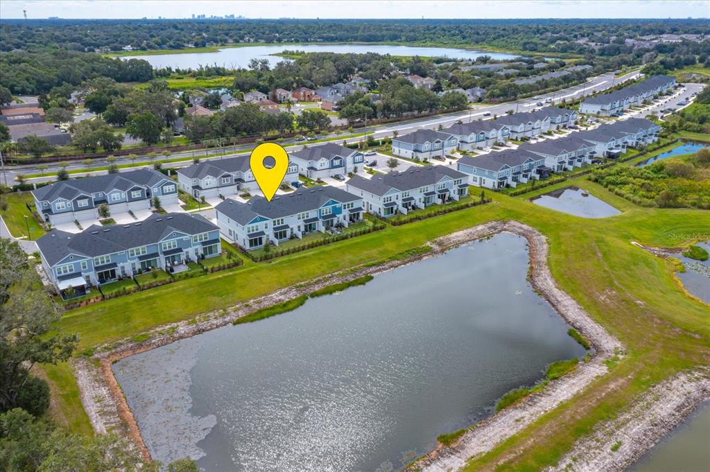 An aerial view shows a row of townhouses situated next to a large retention pond — 1914 TERRAPIN ROAD, OCOEE, FL