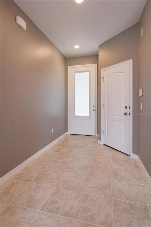 An entryway features beige tile flooring, gray walls, and two white doors — 1914 TERRAPIN ROAD, OCOEE, FL