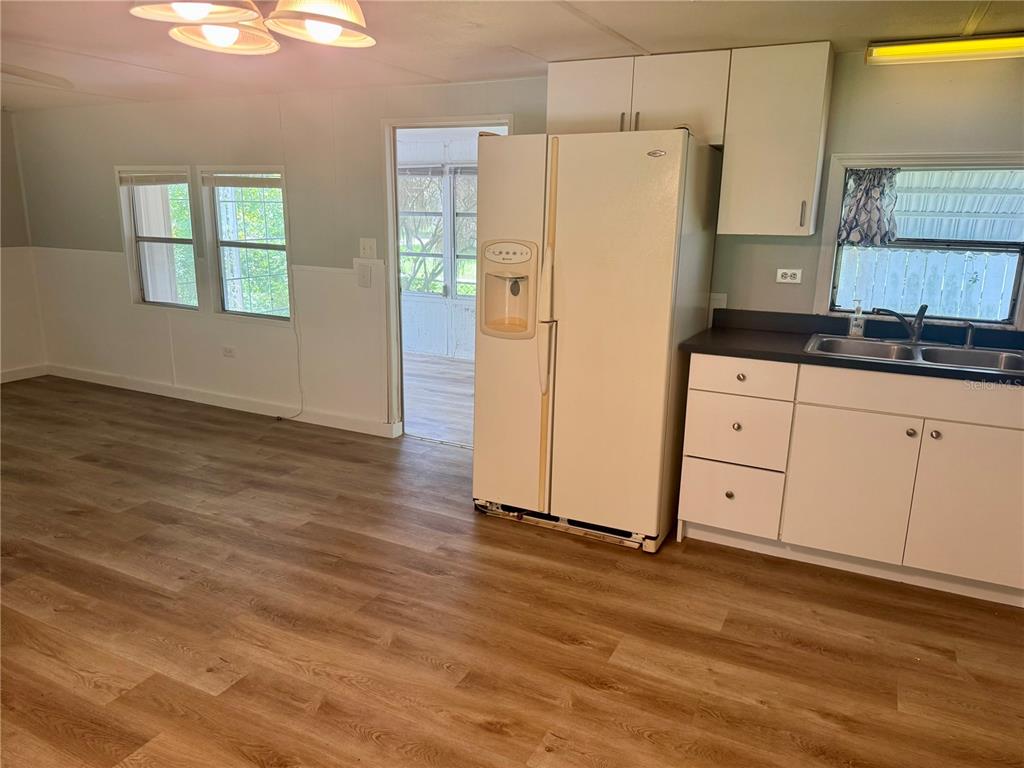 A kitchen features white cabinets, a white refrigerator, and wood-look flooring — 00 FREMONT LANE, SPRING HILL, FL
