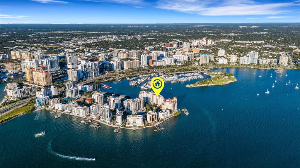 An aerial view shows a waterfront condominium complex on a peninsula in a city — 464 GOLDEN GATE POINT UNIT 403, SARASOTA, FL