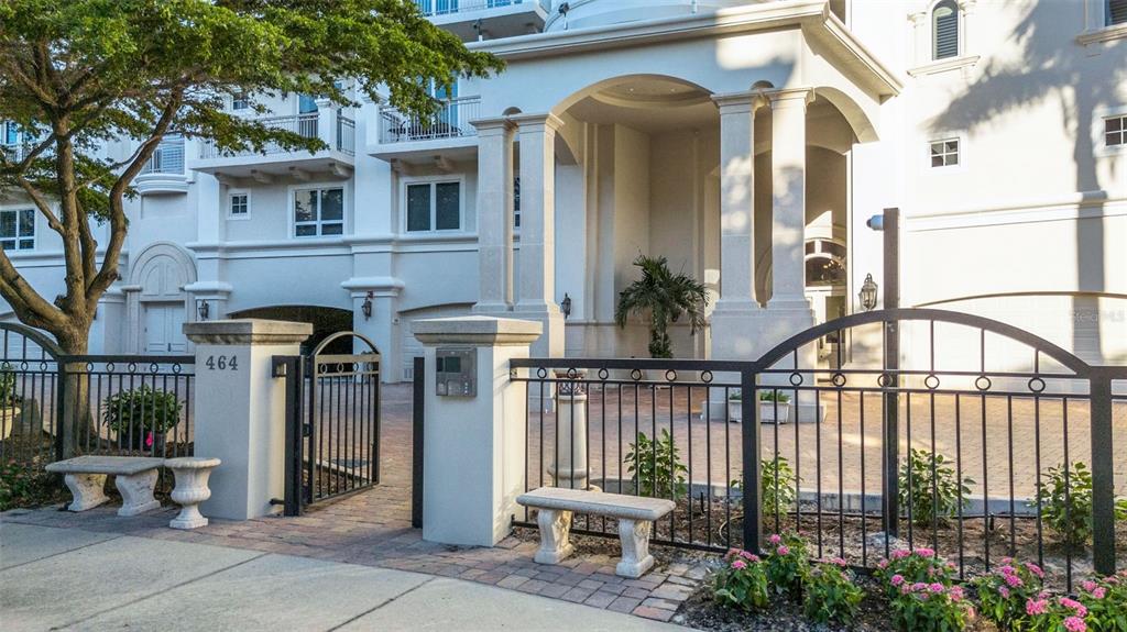 A gated entrance with stone pillars, a wrought iron fence, and a paved driveway — 464 GOLDEN GATE POINT UNIT 403, SARASOTA, FL