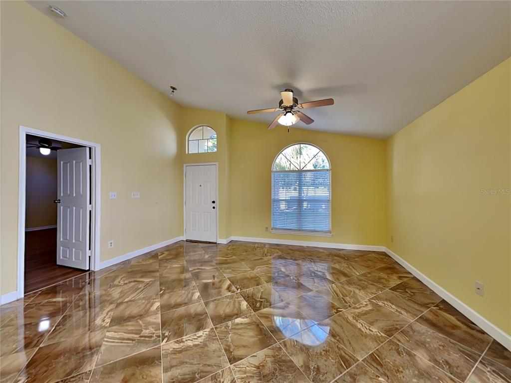 A room with yellow walls, a vaulted ceiling, a ceiling fan, and brown tiled flooring — 502 SAN GABRIEL COURT, WINTER SPRINGS, FL