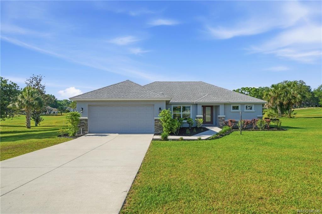 A single-story house with a gray exterior, a two-car garage, and a large front lawn — 594 E HARTFORD STREET, HERNANDO, FL