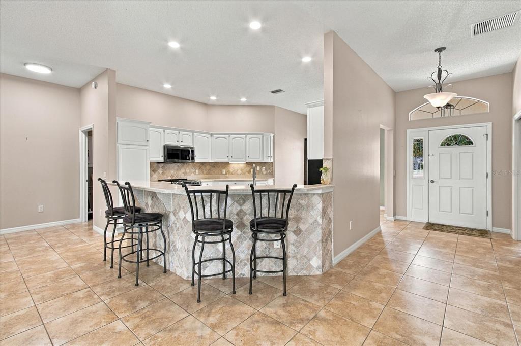 A kitchen with white cabinets, stainless steel appliances, and beige tile flooring — 2314 CALLAWAY DRIVE, THE VILLAGES, FL