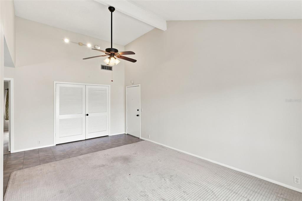 A room with a vaulted ceiling, a ceiling fan, carpeted flooring, and white louvered doors — 438 WINDMEADOWS STREET UNIT 438, ALTAMONTE SPRINGS, FL