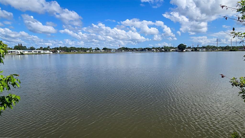 A view of a lake with houses visible along the distant shoreline under a cloudy sky — 300 BEECH COURT, COCOA, FL