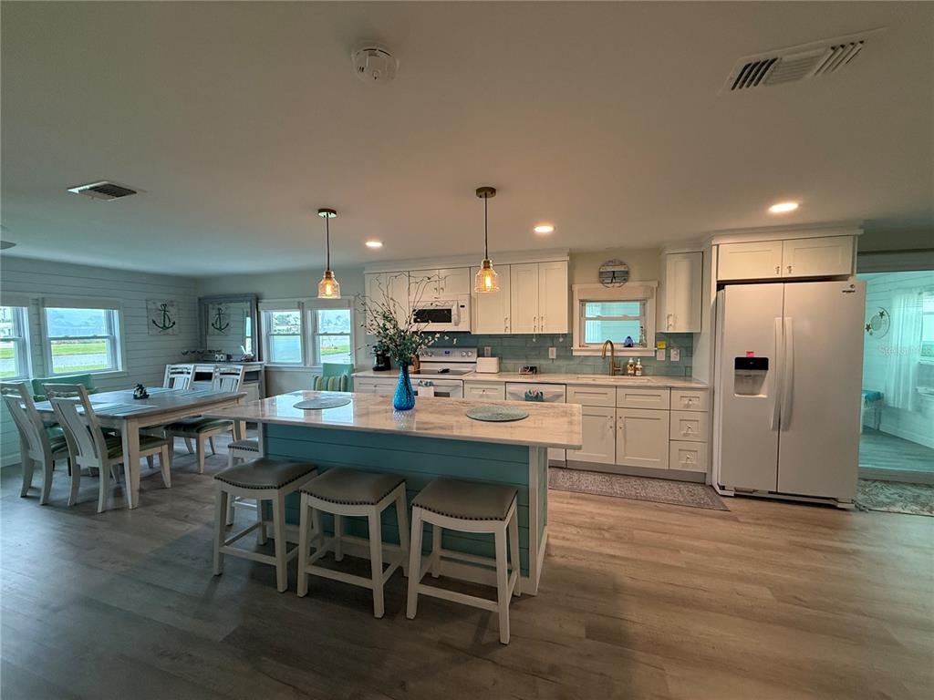 A kitchen with a light blue island, white cabinetry, and a dining area with anchor decor — 637 LOS ALTOS UNIT 374, NORTH PORT, FL