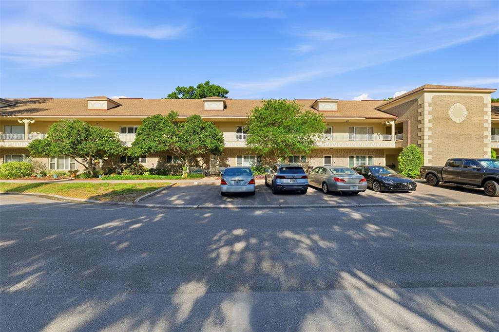 A multi-story apartment building with a brown shingled roof and a parking lot in front — 2192 SWEDISH DRIVE UNIT 26, CLEARWATER, FL