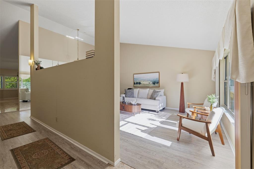 A living room with light wood flooring, a white sofa, and two armchairs — 2192 SWEDISH DRIVE UNIT 26, CLEARWATER, FL