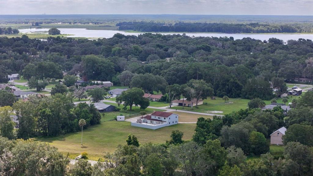 An aerial view shows a two-story house with a fenced backyard in a wooded neighborhood — 7525 E APPLEWOOD DRIVE, INVERNESS, FL