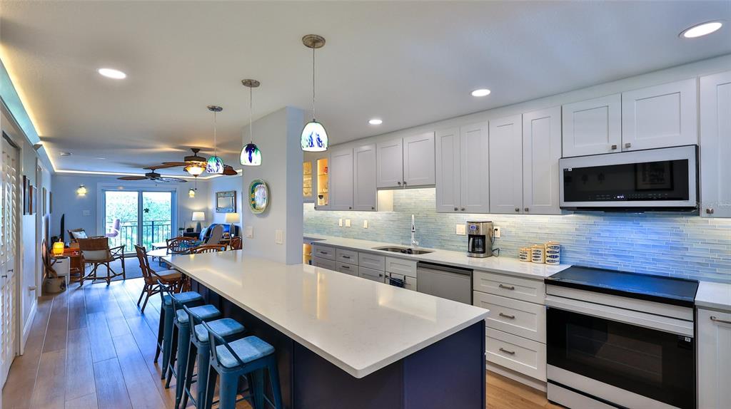 A dining area with a glass table and rattan chairs sits beside a built-in bar — 101 N RIVERSIDE DRIVE UNIT 4120, NEW SMYRNA BEACH, FL