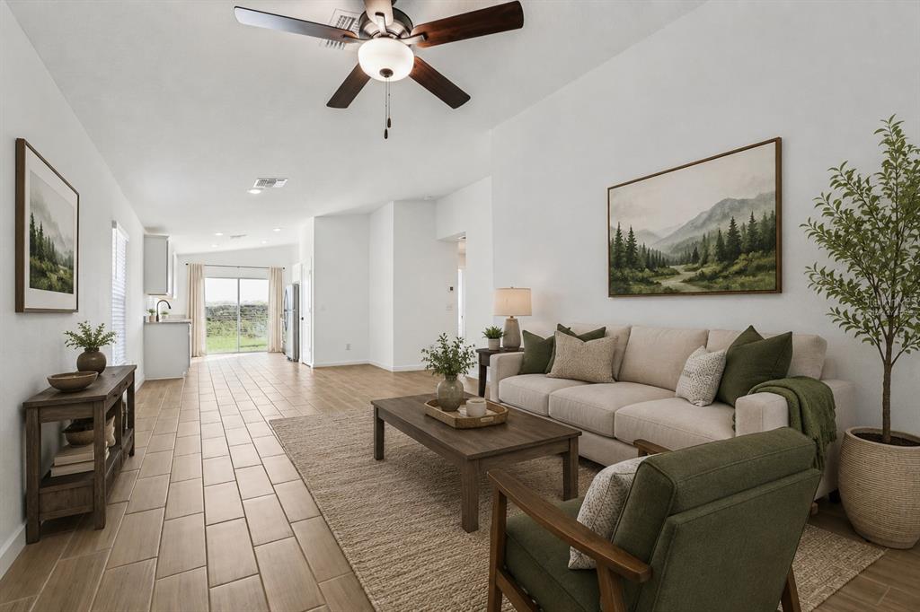 A living room with a beige sofa, green armchair, wood coffee table, and tile flooring — 11308 LINNET ROAD, WEEKI WACHEE, FL