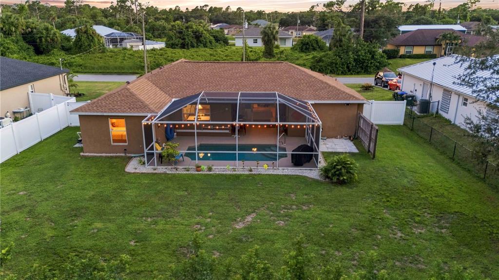 An aerial view of a house backyard featuring a screened-in pool and a grassy lawn — 2144 SMYER AVENUE, NORTH PORT, FL