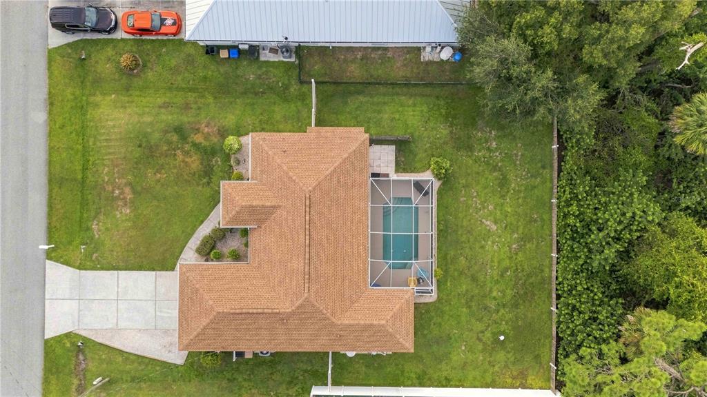 An aerial view shows a house with a brown roof, a pool cage, and a lawn — 2144 SMYER AVENUE, NORTH PORT, FL