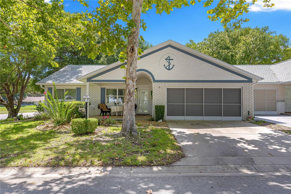 A single-story house with a white brick exterior, a garage, and an anchor wall decoration — 9441 SW 85TH TERRACE UNIT A, OCALA, FL