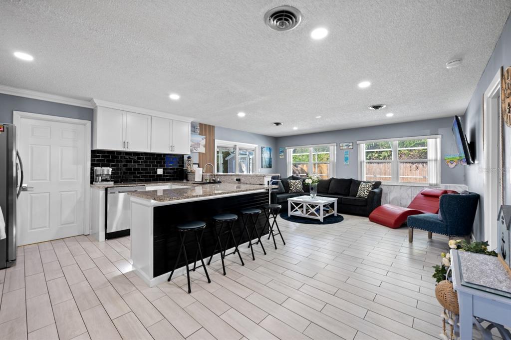 A swimming pool with a stone deck is enclosed by a screened lanai — 874 ACADIA ROAD, VENICE, FL