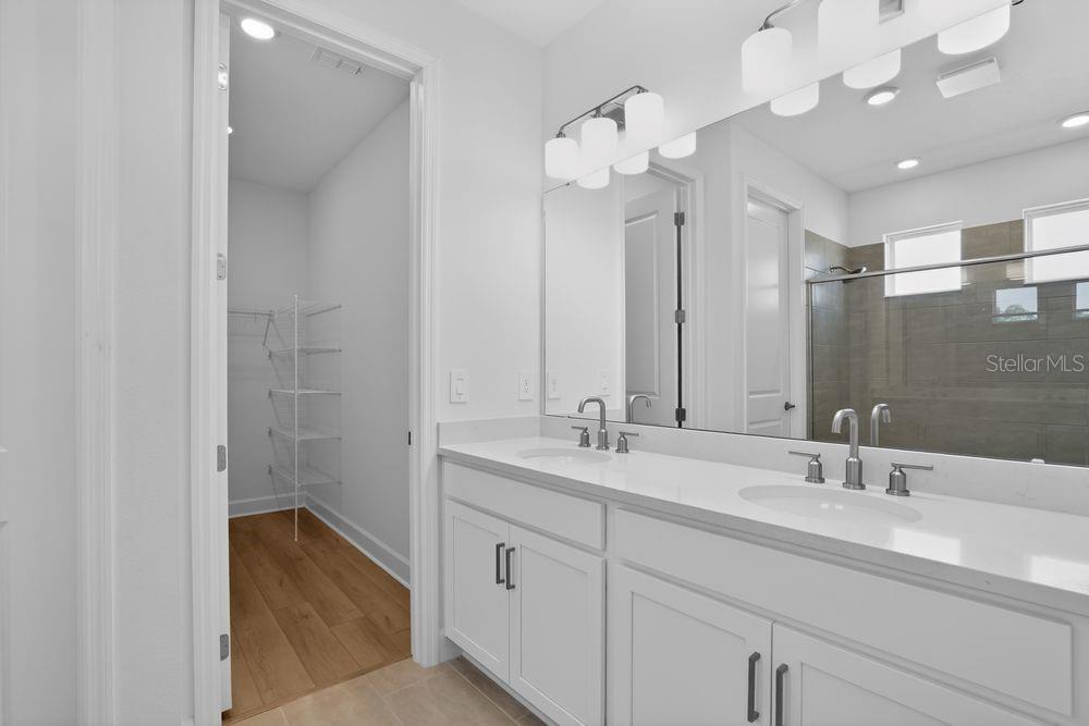 A modern kitchen features white cabinetry, a large center island, and stainless steel appliances — 13333 STABLE PLACE, PARRISH, FL
