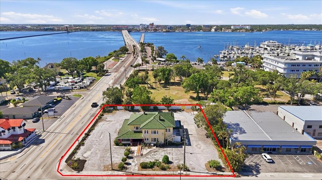 An aerial view shows a yellow house with a green roof on a paved lot — 337 US-41 BUS., PALMETTO, FL