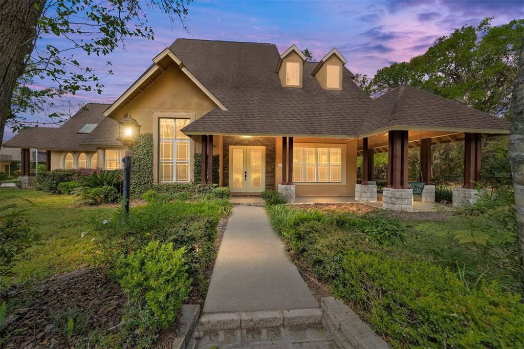 A two-story house with a stone-accented entrance, a covered porch, and a concrete walkway — 16638 N HIGHWAY 329, REDDICK, FL