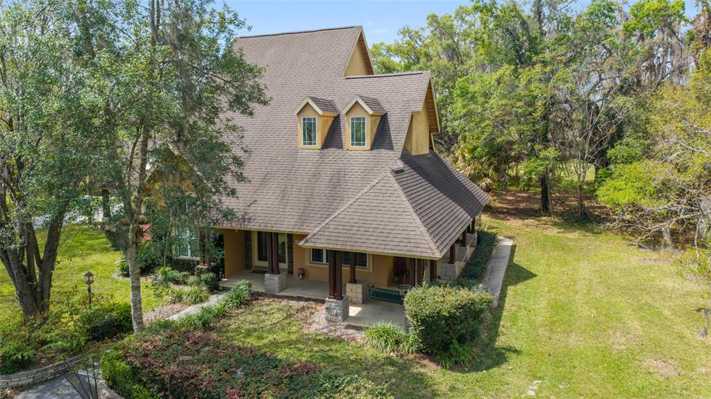 An aerial view of a two-story house with a brown shingled roof and front porch — 16638 N HIGHWAY 329, REDDICK, FL