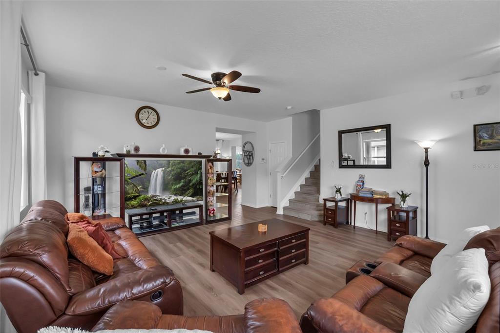 A living room with brown leather sofas, a coffee table, and a large television unit — 711 KETTERING ROAD, DAVENPORT, FL