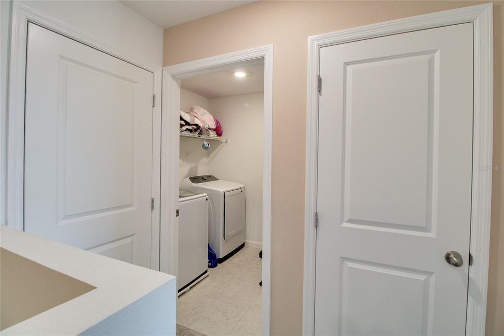 A laundry room with a washer and dryer is visible through an open doorway — 8732 SPORTSMAN LOOP, GROVELAND, FL