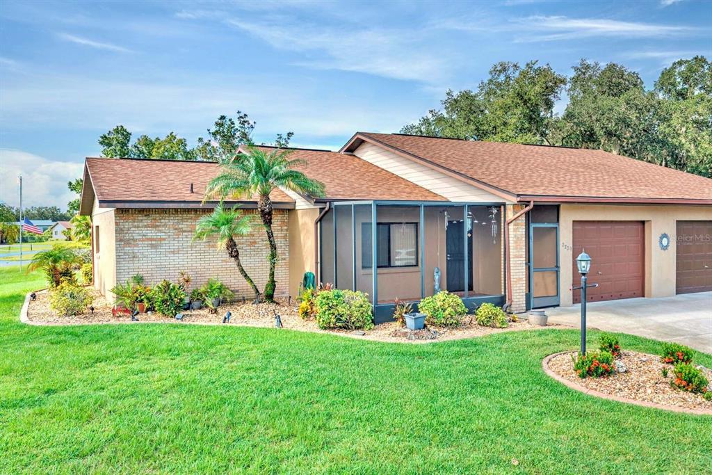 A single-story house with a brick facade, a screened-in porch, and an attached garage — 2209 HIDDEN CREEK CIRCLE, SEBRING, FL