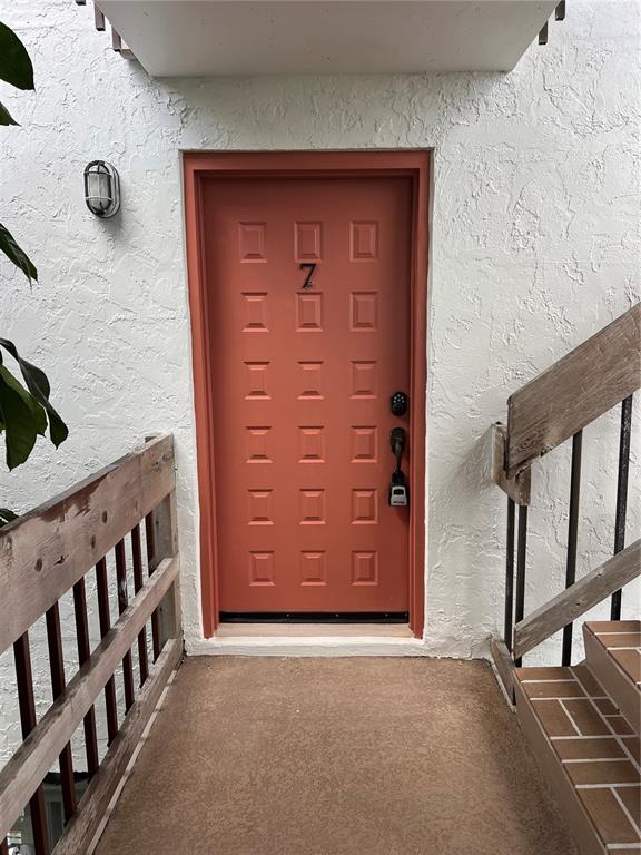 An exterior view of a red front door labeled with the number seven — 4403 7TH STREET E UNIT 7, ELLENTON, FL