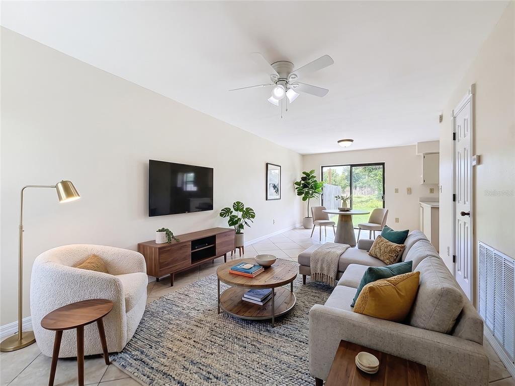 A living room features a sofa, armchair, coffee table, television, and a dining area — 1718 ADAMS CIRCLE S, LARGO, FL