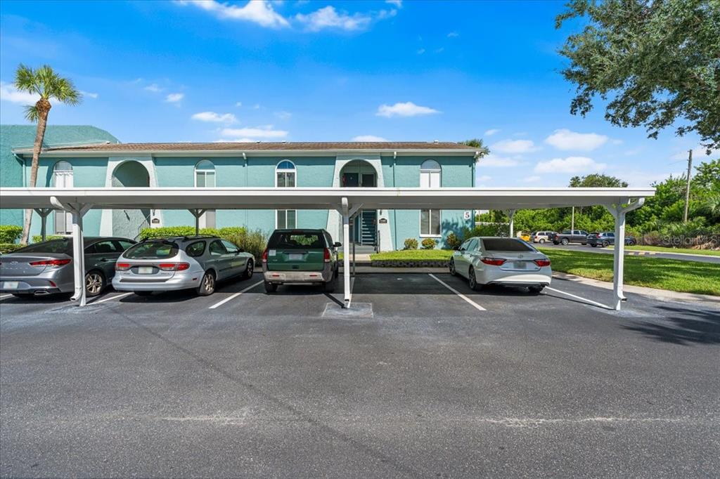 A teal two-story apartment building with a covered parking area in front — 11401 3RD STREET N UNIT 2, ST PETERSBURG, FL