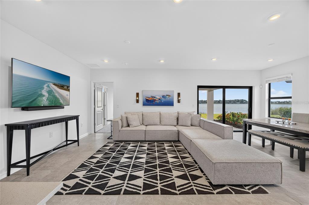 A living room features a sectional sofa, a patterned rug, and a view of water — 6492 SILVERSTAR DRIVE, SARASOTA, FL