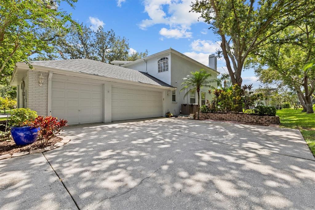 A two-story house with a two-car garage and a concrete driveway under large trees — 2328 WARWICK DRIVE, OLDSMAR, FL