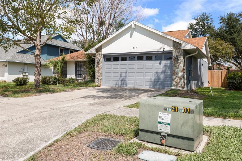 A single-story house with a stone facade, a brown shingled roof, and an attached garage — 1912 FIRETHORN COURT, BRANDON, FL