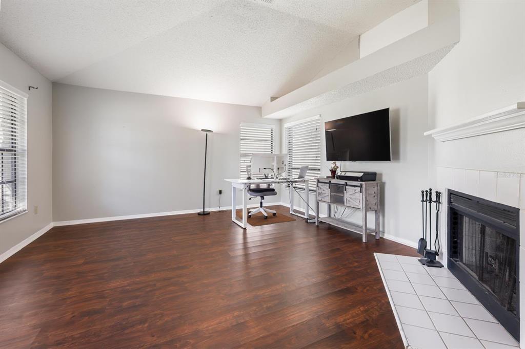 A living room with tile floors, a reclining sofa, and sliding doors opening to a pool — 1912 FIRETHORN COURT, BRANDON, FL
