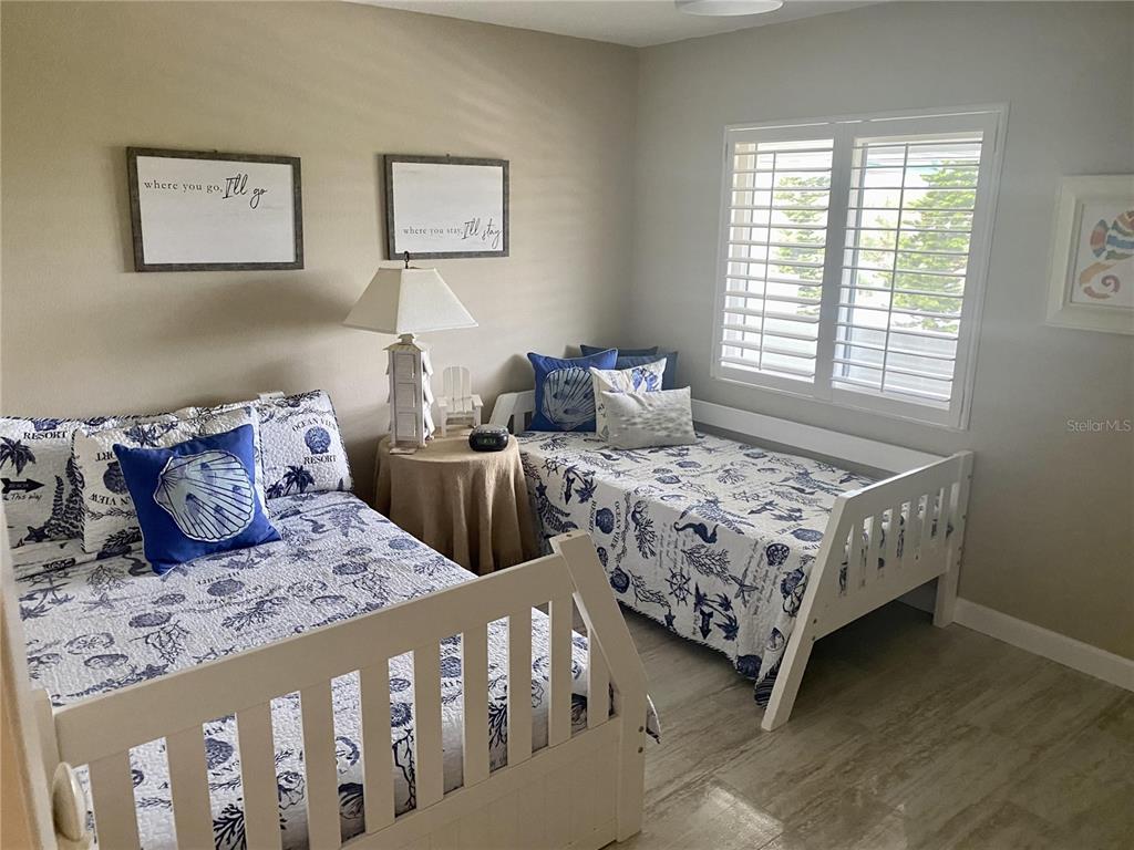 A bedroom features two twin beds with nautical-themed bedding and white wooden frames — 815 OCEAN SHORE BOULEVARD UNIT 8A, ORMOND BEACH, FL