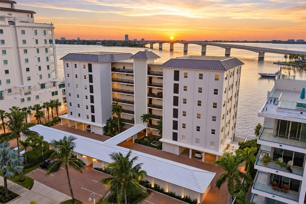 An aerial view shows a multi-story apartment building near a bridge illuminated with red and blue — 226 GOLDEN GATE POINT UNIT 12, SARASOTA, FL