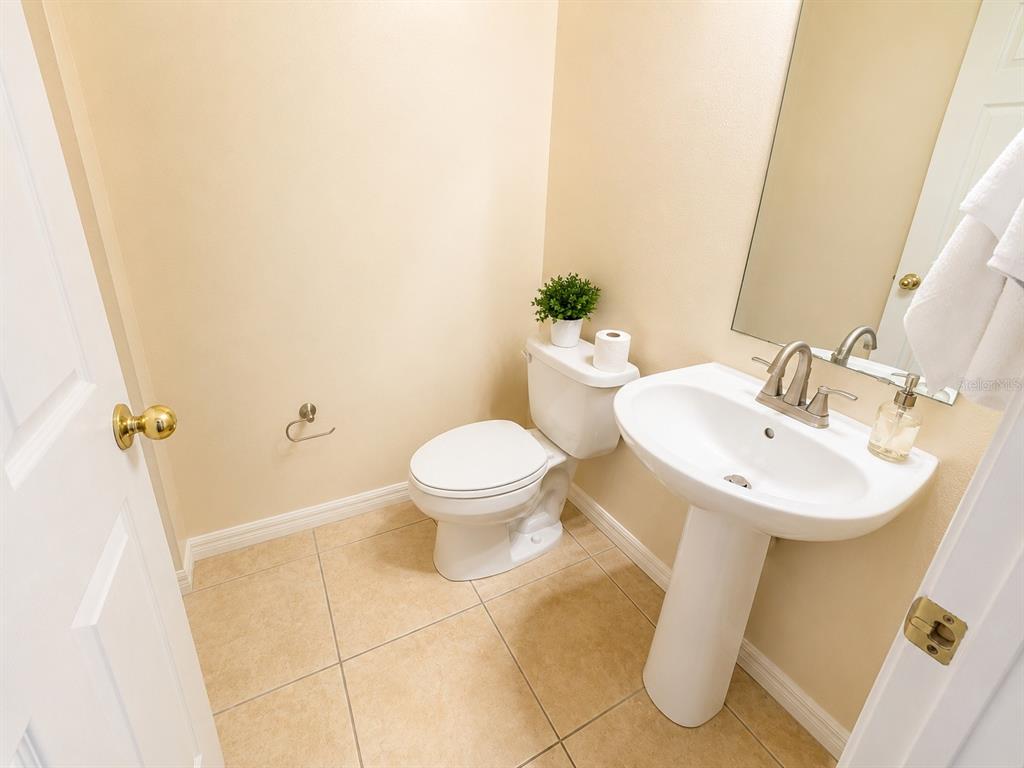 A kitchen with granite countertops and light wood cabinets opens to a dining area — 7601 ACKLINS ROAD, KISSIMMEE, FL