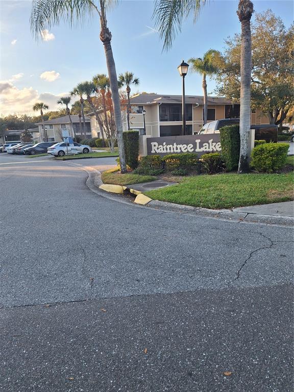 A sign for Raintree Lake stands in front of apartment buildings with palm trees — 11910 SKYLAKE PLACE UNIT E, TEMPLE TERRACE, FL