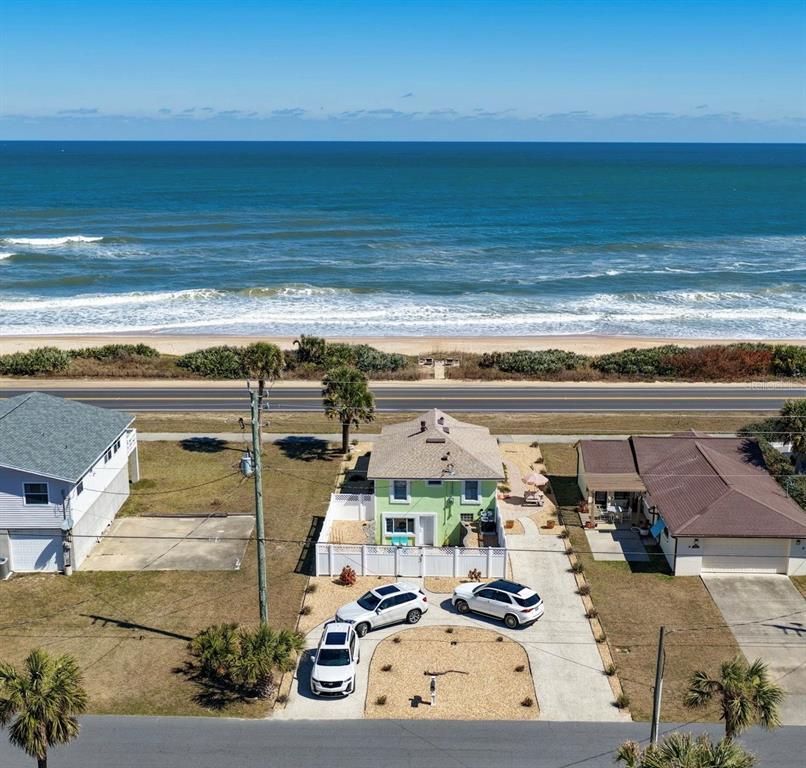 An aerial view shows a light green house near a beach with three parked cars — 1349 N OCEAN SHORE BOULEVARD, FLAGLER BEACH, FL