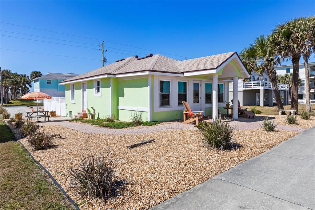 A light green, single-story house with a covered porch and a gravel front yard — 1349 N OCEAN SHORE BOULEVARD, FLAGLER BEACH, FL