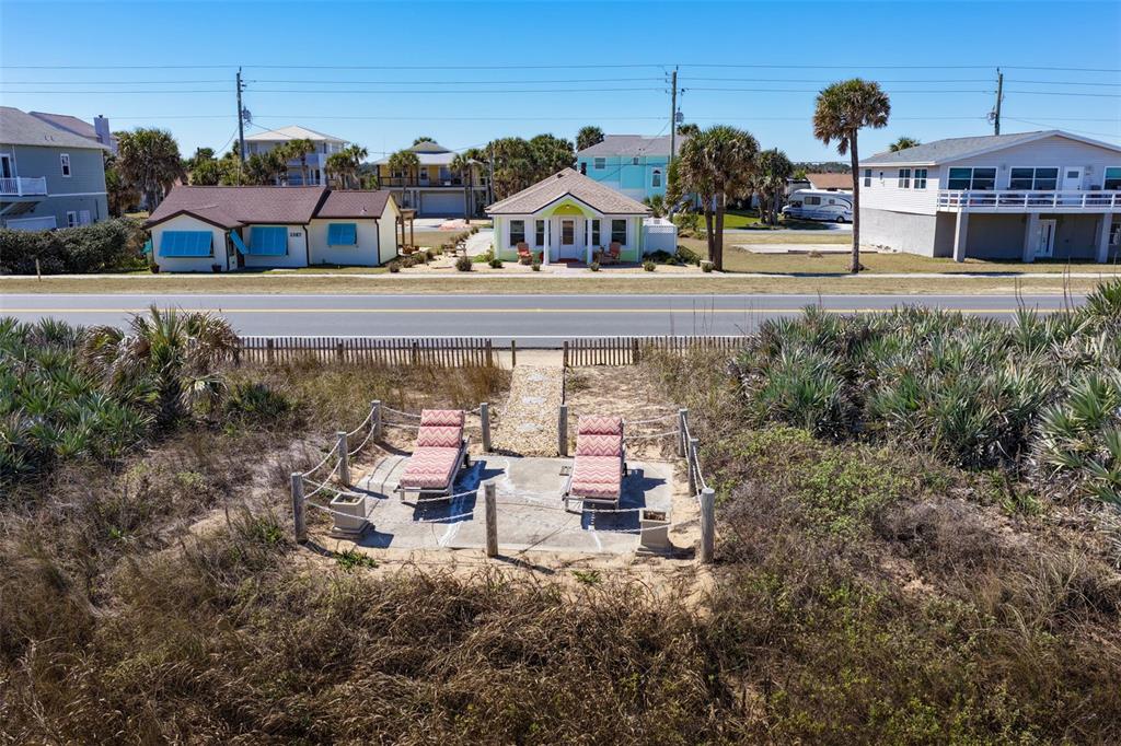 An elevated view shows two lounge chairs on a patio overlooking a coastal road — 1349 N OCEAN SHORE BOULEVARD, FLAGLER BEACH, FL