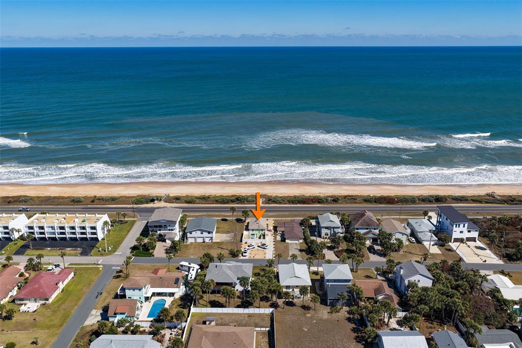 An aerial view shows a beach house with an orange arrow pointing toward it — 1349 N OCEAN SHORE BOULEVARD, FLAGLER BEACH, FL