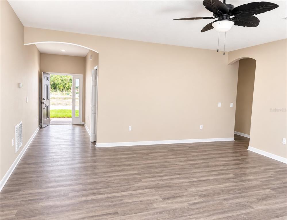 An unfinished room with beige walls, concrete flooring, and an open doorway leading outside — 411 SHANNON ESTATES COURT, PLANT CITY, FL