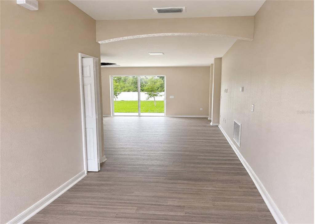 An unfinished room with concrete flooring, a ceiling fan, and a sliding glass door — 411 SHANNON ESTATES COURT, PLANT CITY, FL
