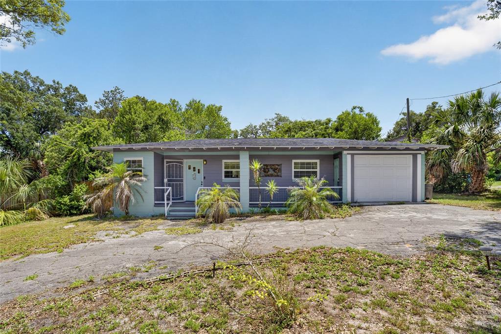 A single-story house with a light blue and purple exterior, porch, and attached garage — 129 COLOMBA ROAD, DEBARY, FL